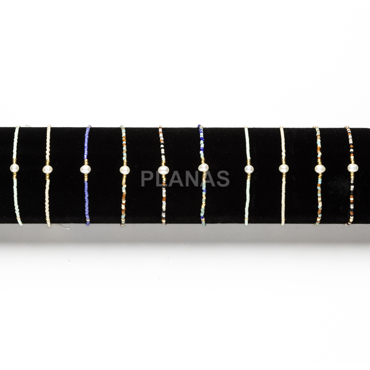Expositor de 10 pulseiras de latão e pérolas cultivadas em cores variadas.  