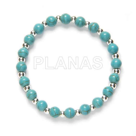 Elastic bracelet with reconstituted turquoise balls and sterling silver.
